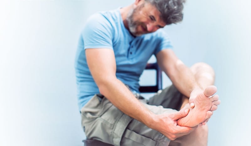 Man in pain holding foot with plantar fasciitis